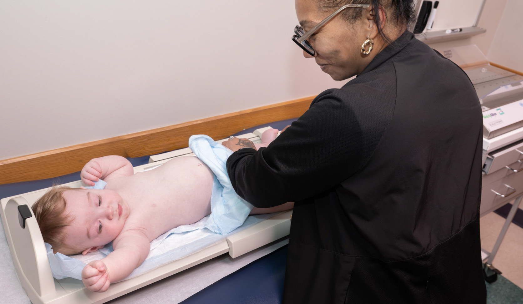 Image of a provider weighing a baby
