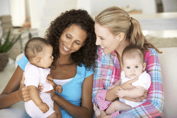 2 young moms holding their babies