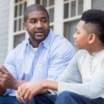 Teen son and dad talking.