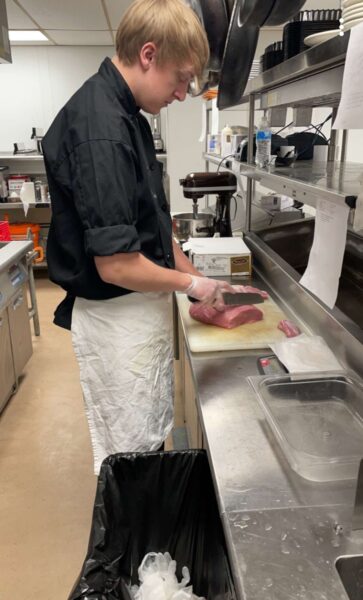 Evan Wooldredge cutting meat