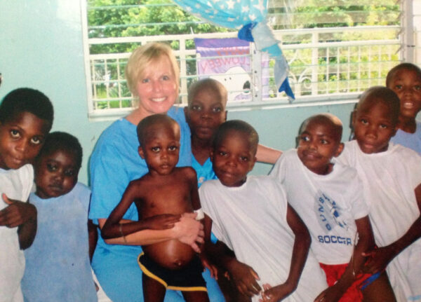 Diane Bueker, pediatric cardiac sonographer, with several Haitian boys