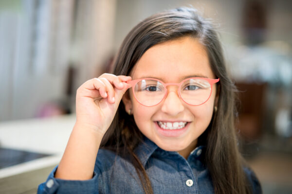 Little girl trying glasses at the optician