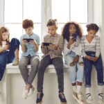Children of different nationalities play online games or read social networks on mobile phones.