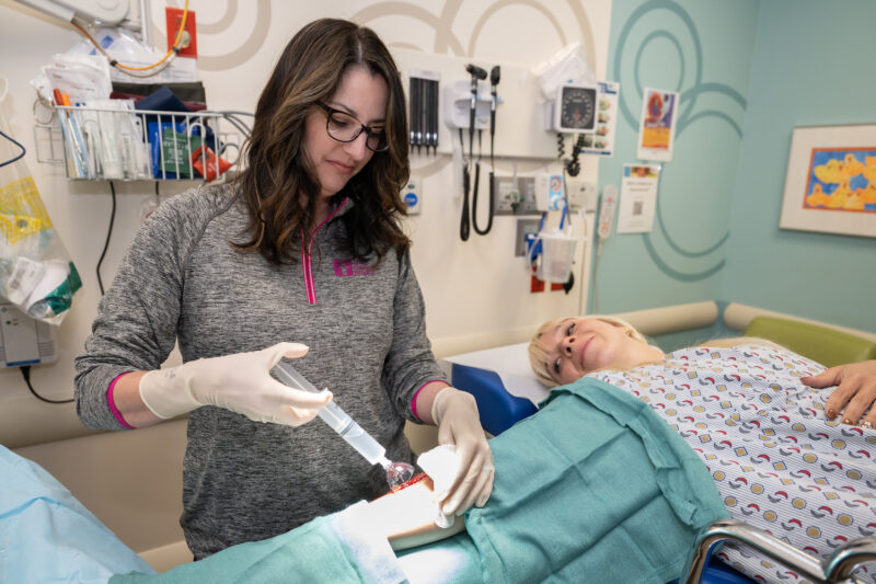 Jennifer Marshall sutures a patient's arm