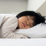 How to get your child to sleep in their own bed Portrait of Asian child sleeping on the bed