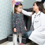 Child getting measured at pediatrician's office