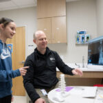 Ahead of the curve: Spinal tethering surgery helps gymnast recover from scoliosis Mady and Dr. Ritzman look at her before and after spine x-rays.