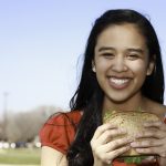Smiling Young Woman Eating Healthy Sandwich at a Park