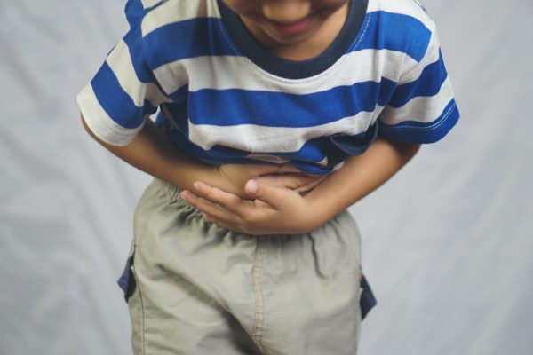 A boy has a stomach ache from not eating at the right time.