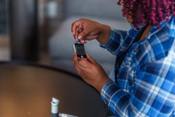GettyImages-woman checking her blood sugar