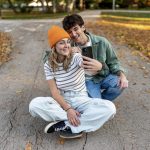 Smiling young couple taking selfie with smartphone in park