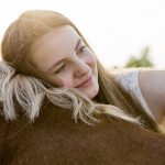 Hope and healing through horse-assisted therapy GettyImages-girl hugging horse resized