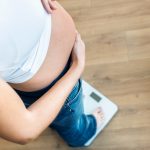 How much pregnancy weight gain is healthy? GettyImages-pregnant woman on scale