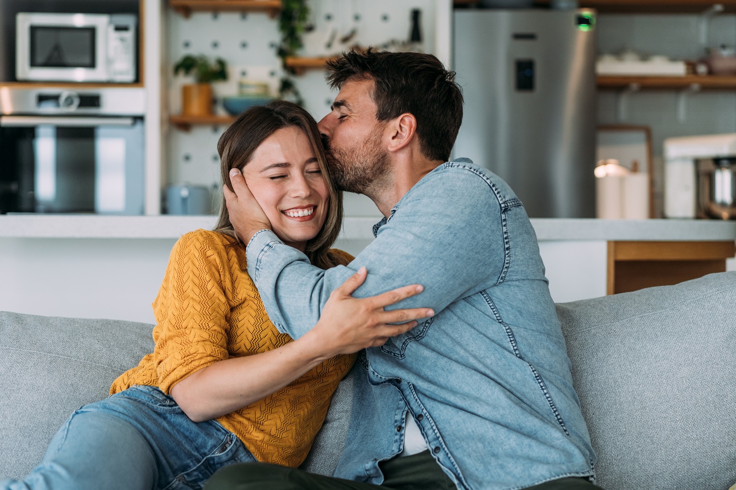 Young couple kiss on couch - resized for blog