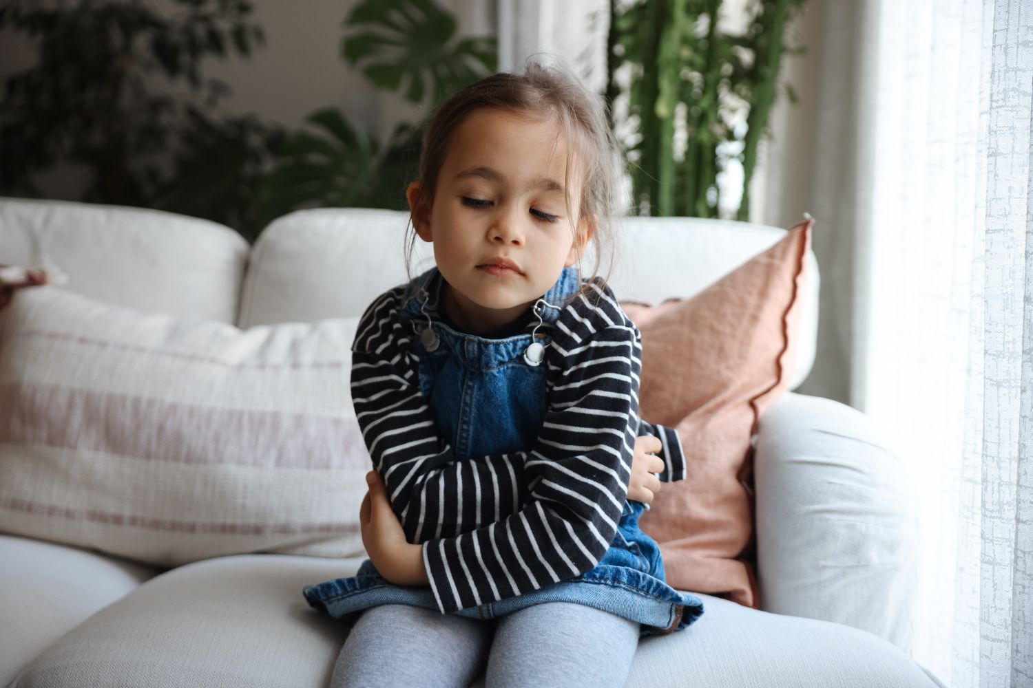 Young girl with stomachache holding her belly