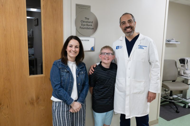 Patient Jake Morrison with his mom and Dr. Dr. Faruk Örge, outside the Akron Children's dilation room named after the Cleveland Eye Bank Foundation.
