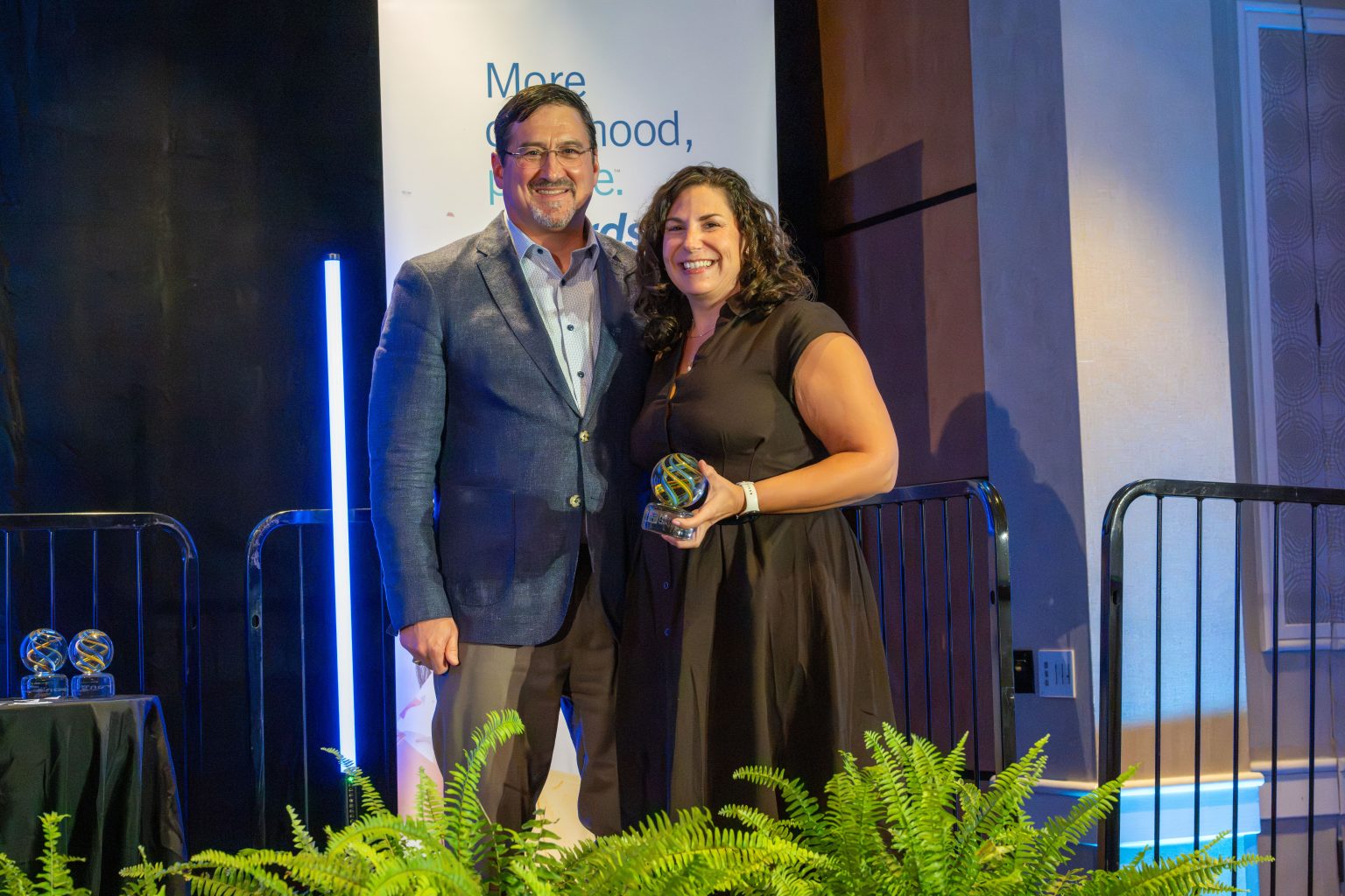 Akron Children's CEO Chris Gessner on stage to congratulate Teresa Fletcher, holding her Luminary award at the Akron Children's "More childhood, please." awards.